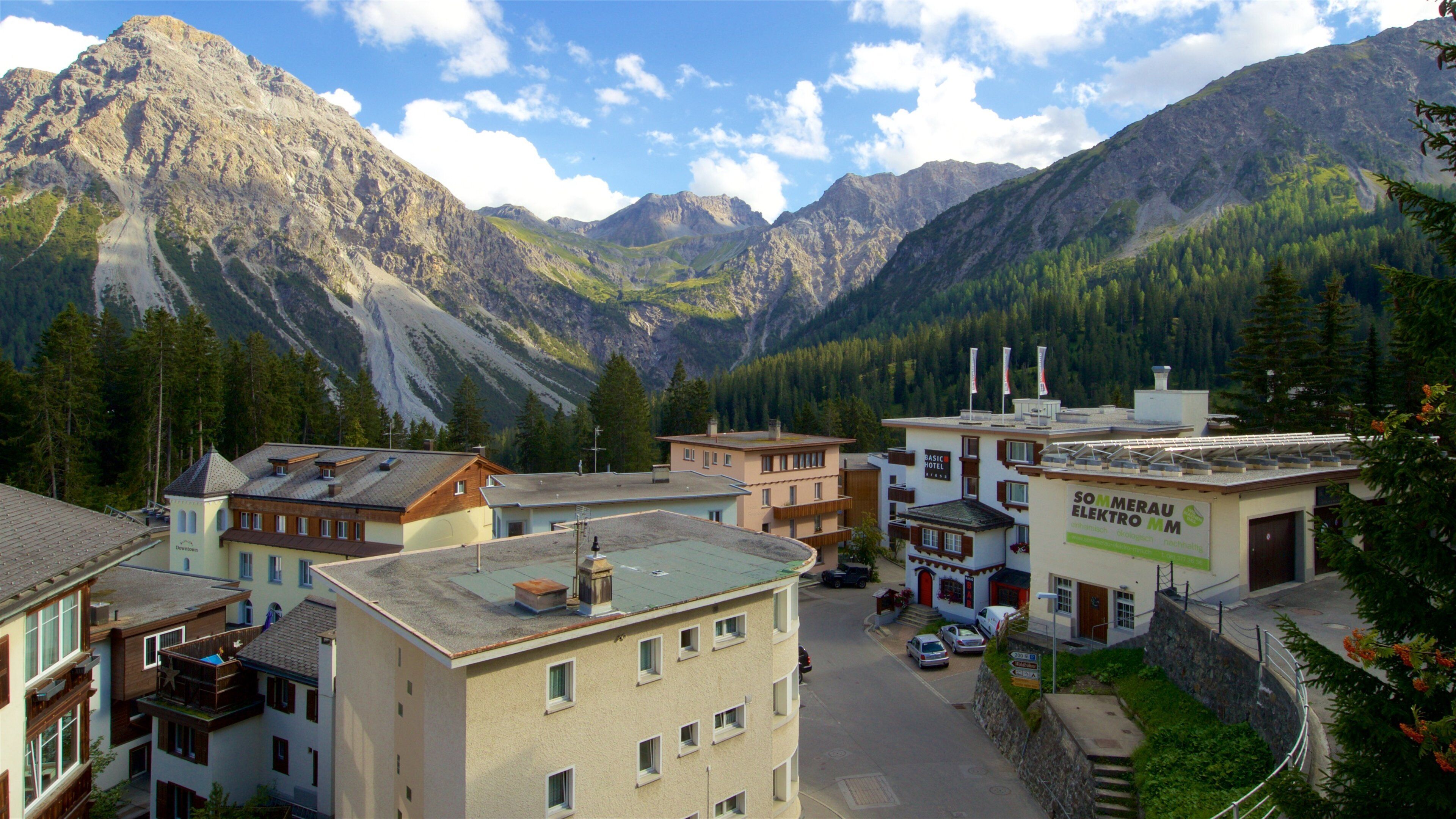 A mountain town with buildings, a road, and a large mountain in the background.
