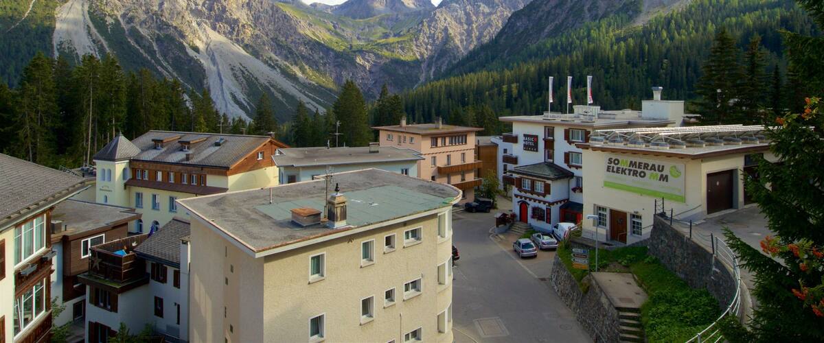 A mountain town with buildings, a road, and a large mountain in the background.