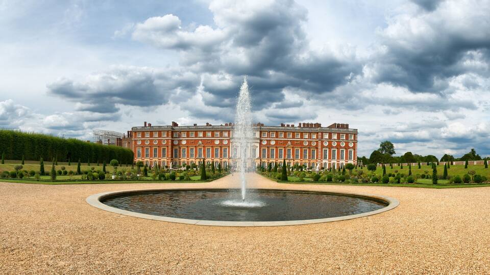 A large red building with a fountain in front.