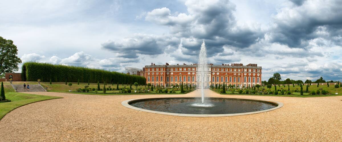 A large red building with a fountain in front.