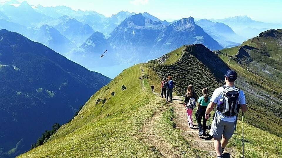 A hiking trail on a mountain with a clear sky and distant mountains.