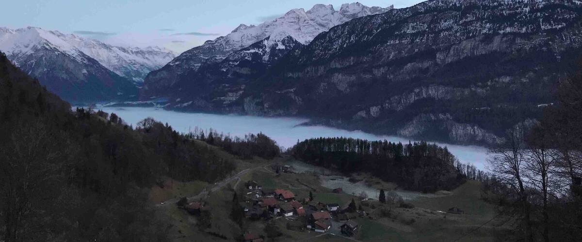 A mountainous landscape with a lake and a small village.