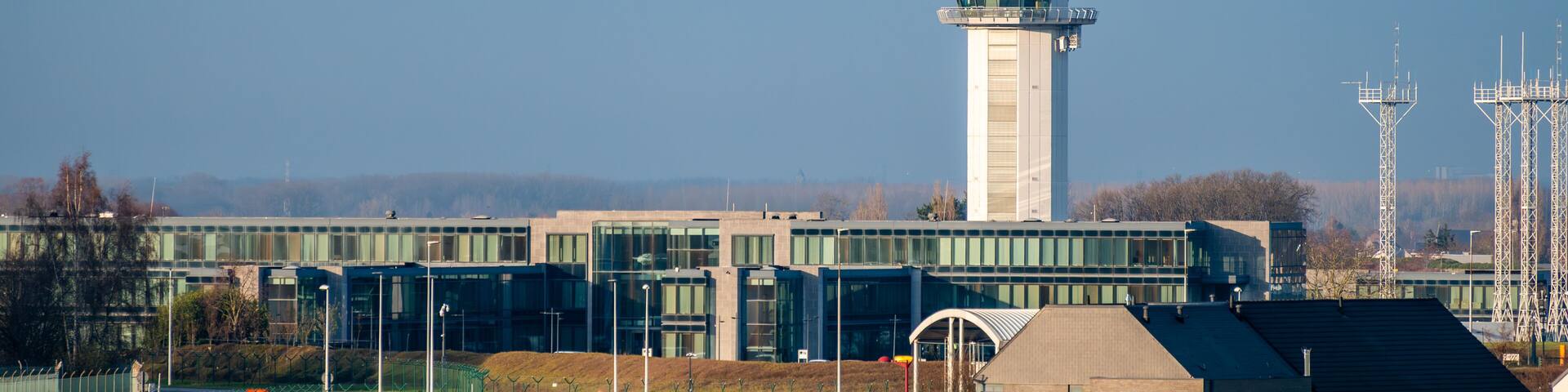 Brussels Airport control tower and skeyes buildings under blue sky