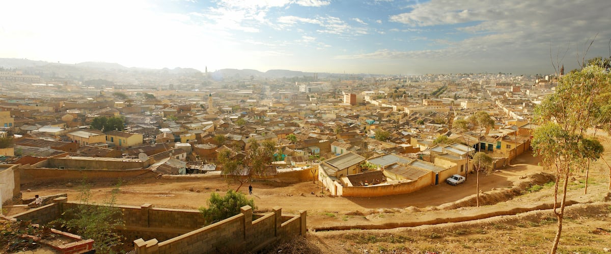 A densely populated urban area with numerous buildings and a prominent mosque.