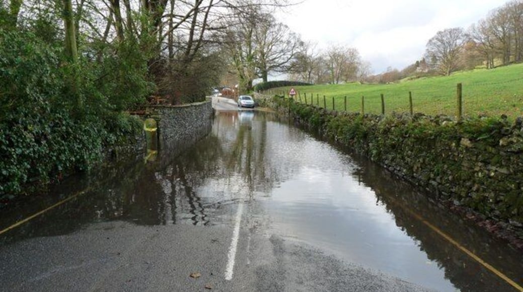 The B5285 flooded at Near Sawrey, Cumbria The yellow and white lines quickly disappeared from view under the water. I judged it be too deep to drive through. Fortunately the road was passable via a short cut behind the property to the left of this photograph. It took me five hours to drive from Near Sawrey to Kendal, normally a 14 mile drive.