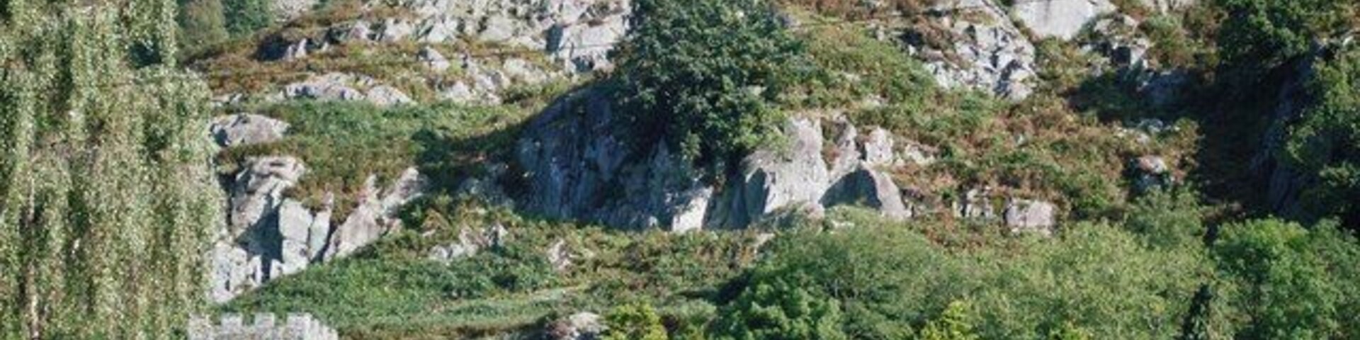 Un paisaje montañoso con terreno rocoso, una iglesia y un edificio residencial.