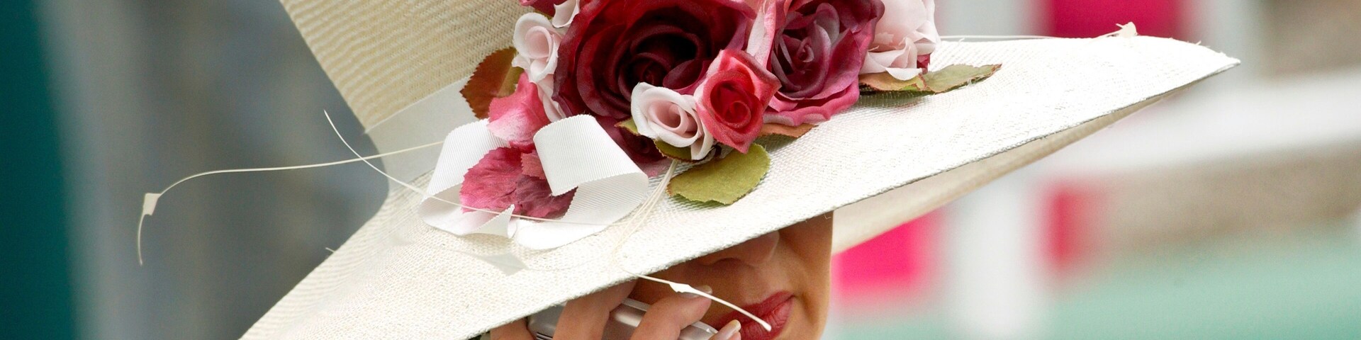 A person wearing a white hat with a floral decoration.