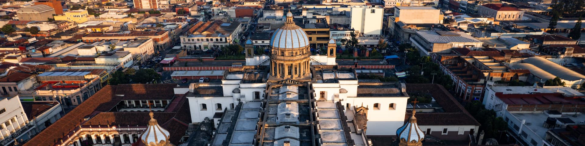 A cityscape with a prominent cathedral featuring a large dome and two bell towers.