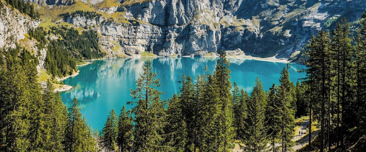 A mountain lake surrounded by rugged peaks and dense forests.