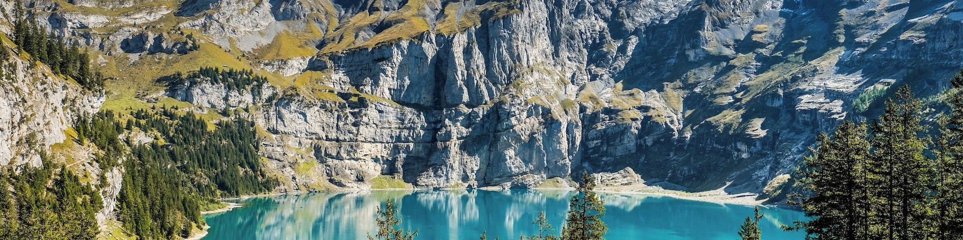 A mountain lake surrounded by rugged peaks and dense forests.