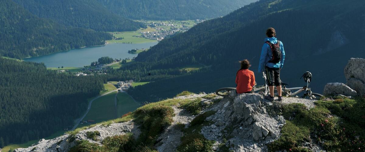 A mountainous landscape with a lake and a town in the valley.