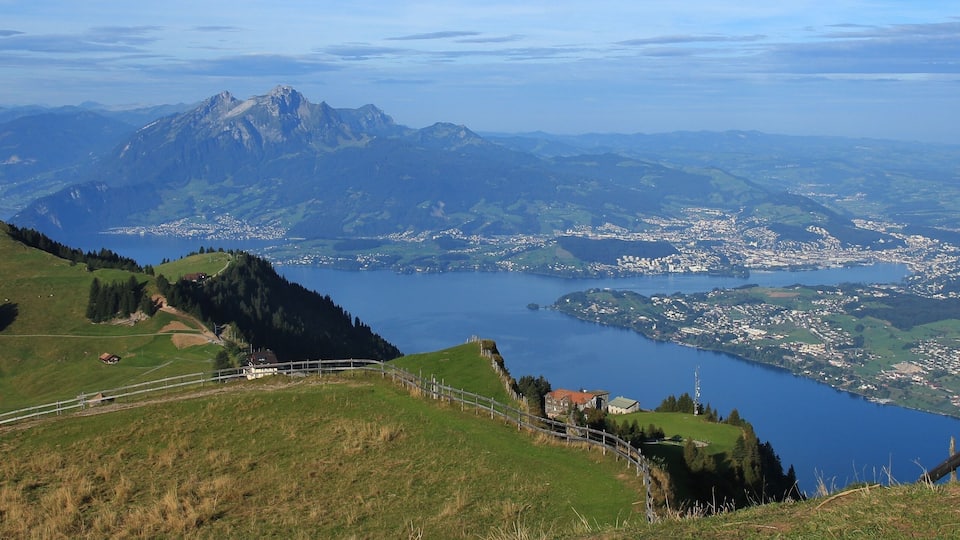 A mountainous landscape with a lake, a town, and a prominent peak.