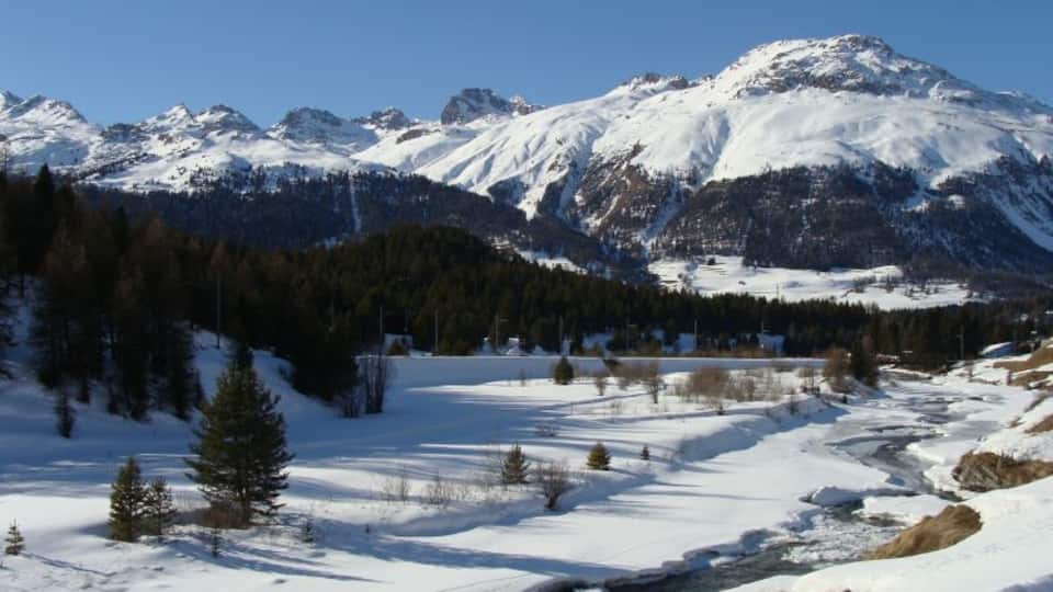 A snow-covered mountain range with a clear sky.