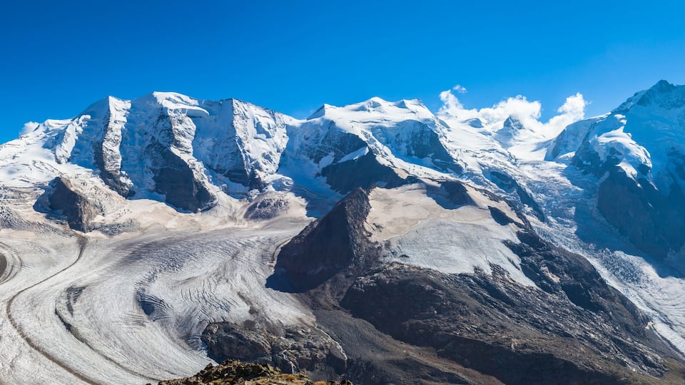 A glacier with rugged mountain peaks in the background.