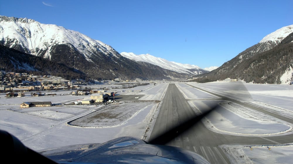 Eine schneebedeckte Startbahn mit Bergen im Hintergrund.