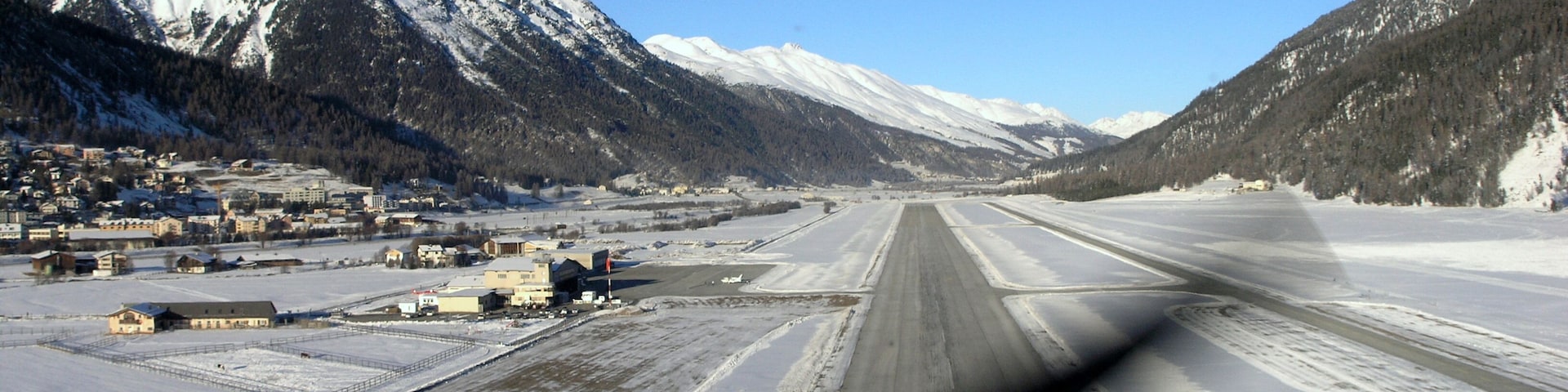 Una pista cubierta de nieve con montañas al fondo.
