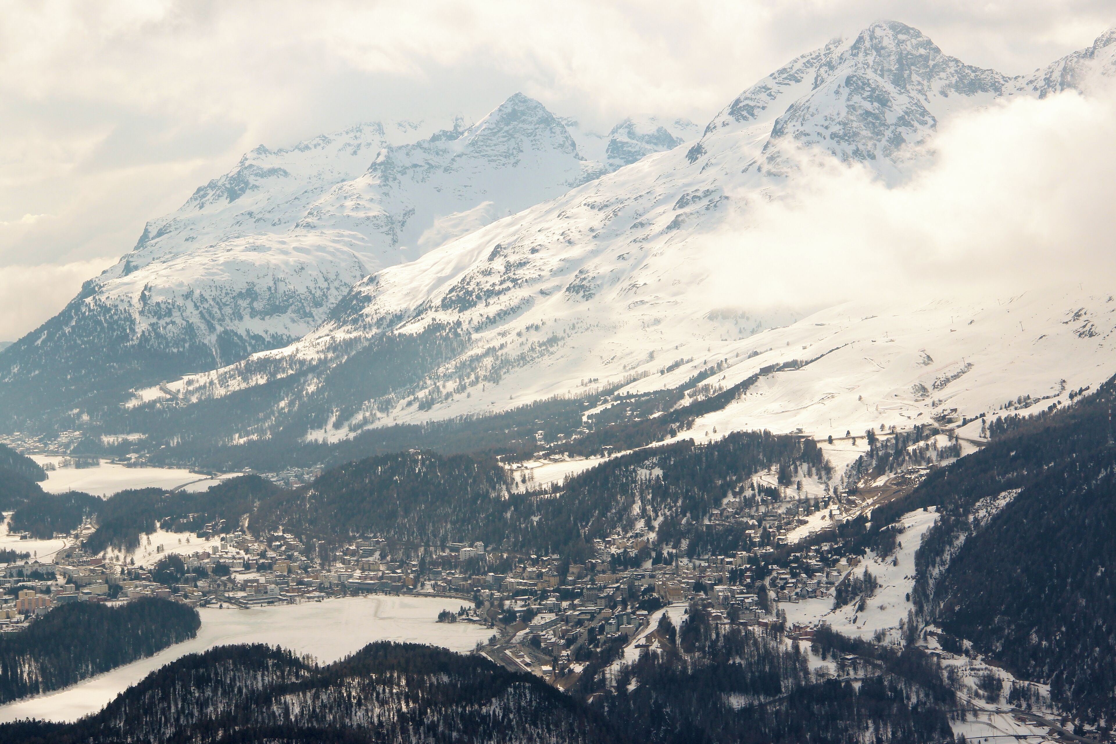 A snow-covered mountain range with a town nestled at the base.