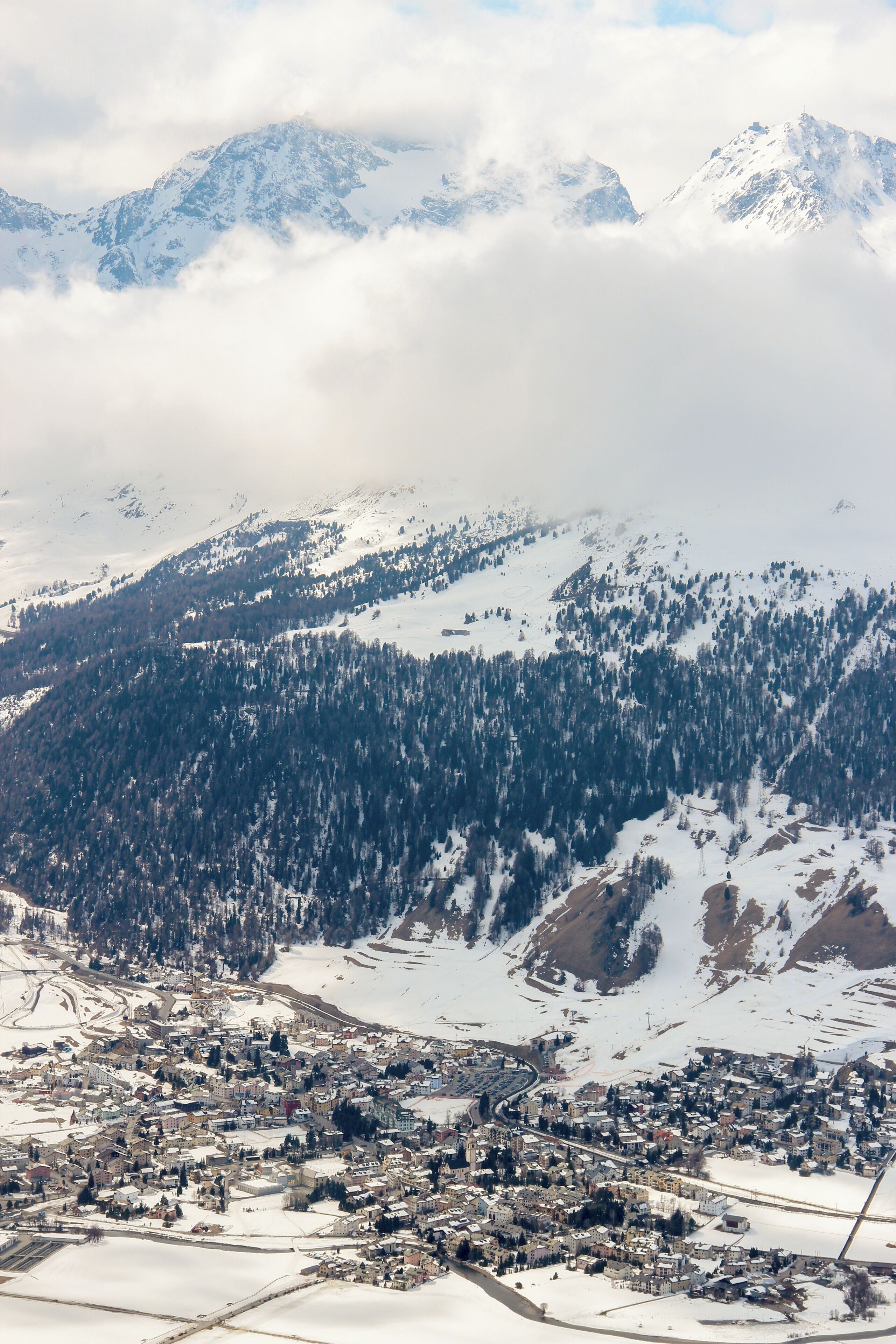 A snow-covered mountain range with a town nestled at its base.