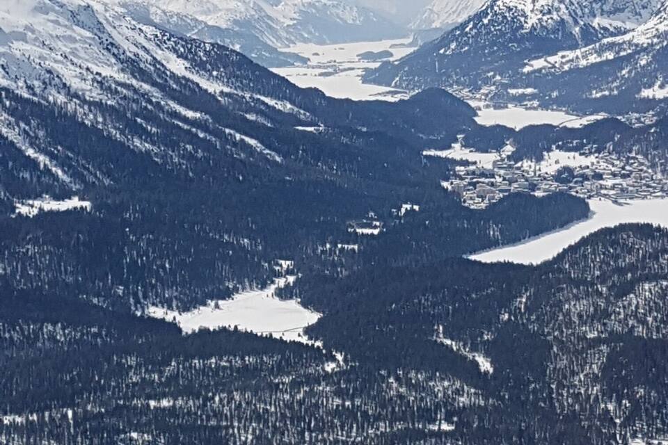 Una cadena de muntanyes cobertes de neu amb una vall i un llac.