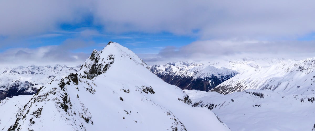 A snow-covered mountain range with rugged peaks and valleys.
