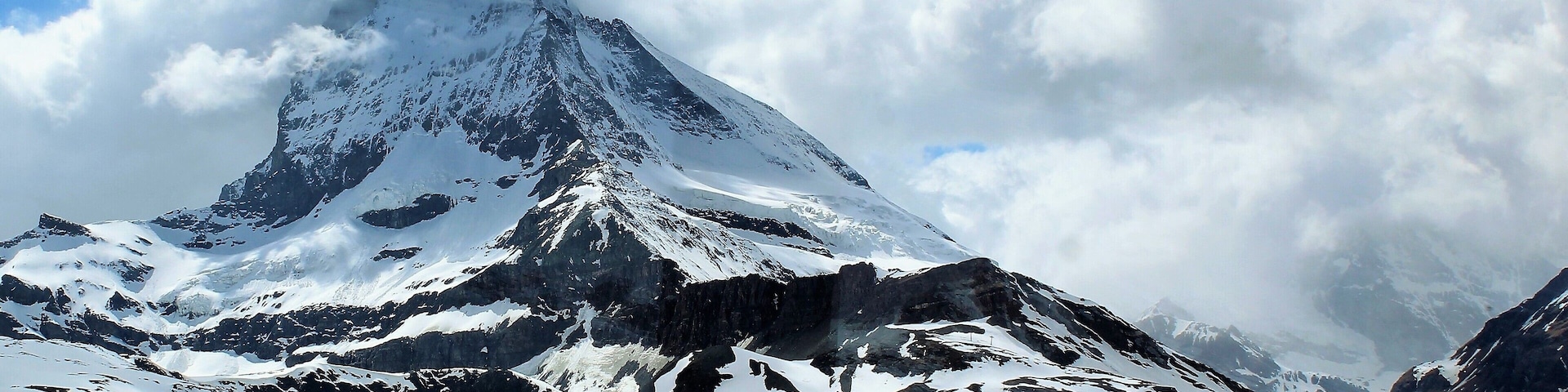 I took this in Zermatt, Switzerland on May 29th :). This was taken on the train from Gornergrat to Zermatt center. So the map location is only approximate. 
I had a great, short trip to Switzerland after a likewise trip to Madeira and Lisbon!  And this day trip to see Matterhorn being the final day. Matterhorn being one of the most epic mountains in all of Europe and also one of the highest. It stands at 4,478 m (14,692 ft) and really does look it!
I took the train up to Gornergrat (which is at 3,135 m/10,285 ft).. And then the train back down to the Zermatt center. The view from Gornergrat was amazing, too, but the Matterhorn top was enshrouded in clouds. Going back the clouds finally started to move! And I got some pretty decent shots. Also, it was a thrilling experience being up there at Gornergrat. Despite it being late Spring it was very much like Winter! The temperature was supposedly around -6 C/21.2 F. And obviously so much snow all around. I got great views of the glacier, too. Inside the train it was much warmer, though ;). I then took the train back to Visp where I was staying. And the next day my trip was over. But was a great way to end an epic 2 weeks! And especially happy to see something I've dreamed of for so long - the majestic Matterhorn.