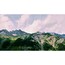 Ein Gebirge mit schneebedeckten Gipfeln, dichten Wäldern und einem bewölkten Himmel.