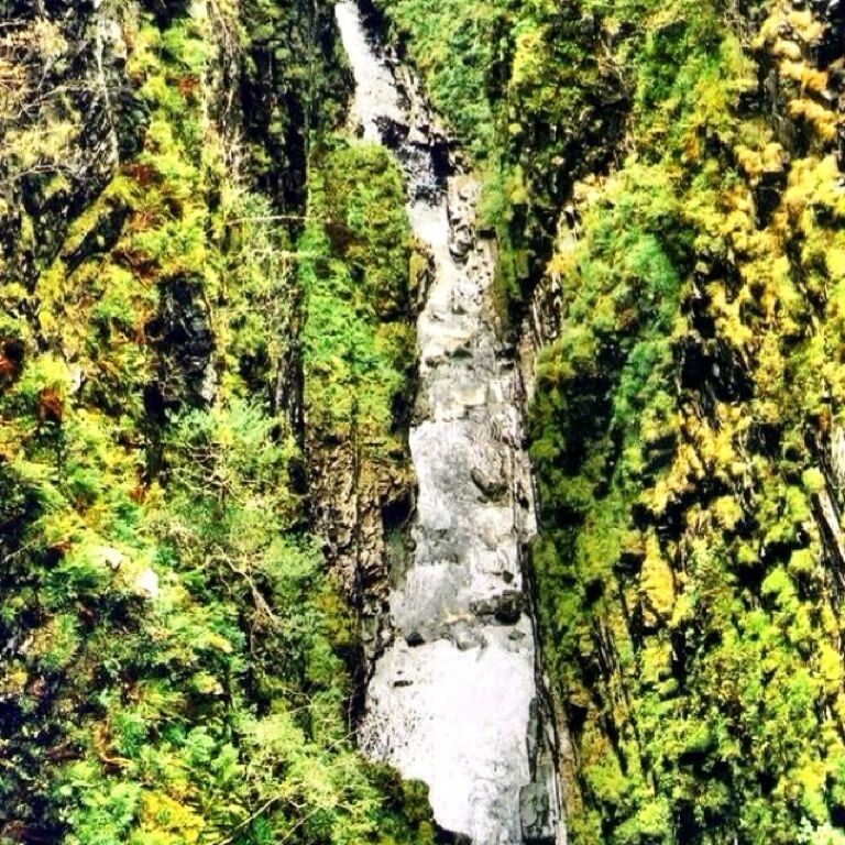 
Corrieshalloch Gorge shows the formidable forces of nature at their most impressive. It is a slot gorge, or box-canyon, cut by glacial meltwater between 2.6 million and 11,500 years ago. Through its narrow and steep-sided length flows the water of the River Droma, dropping 100m over the course of its 1.25km journey in a series of waterfalls, the most dramatic of which is the 45m Falls of Measach.

For many, the highlight of a visit is a walk across the bridge and the deep chasm below. Spanning just over 25m from ledge to ledge the bridge sways gently in the wind, providing an exhilarating experience!

It was built in 1874 by Sir John Fowler, one of the designers of the famous Forth Rail Bridge. #trover
