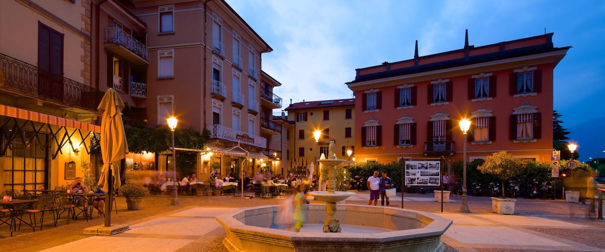 A square with a fountain, outdoor seating, and historic buildings.