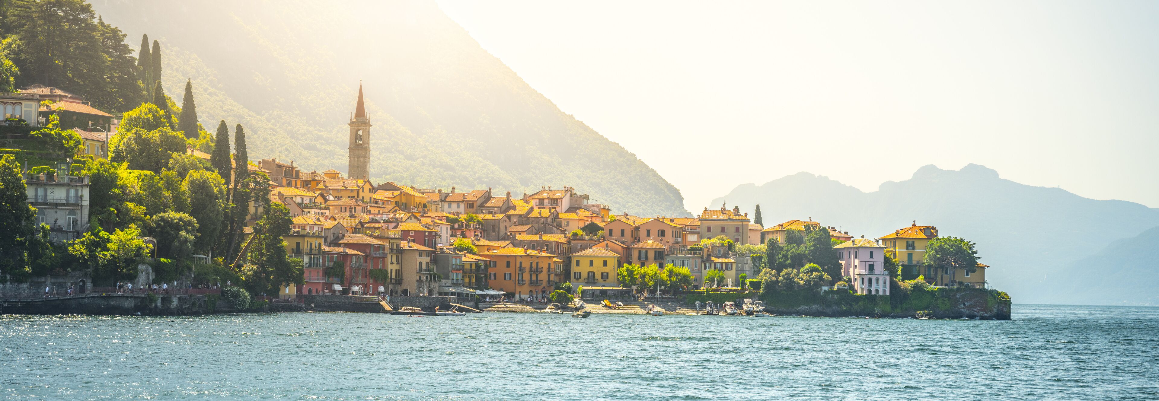Menaggio sits gracefully along the shores of Lake Como, showcasing its charming architecture and stunning natural surroundings illuminated by warm sunlight, creating a picturesque experience.