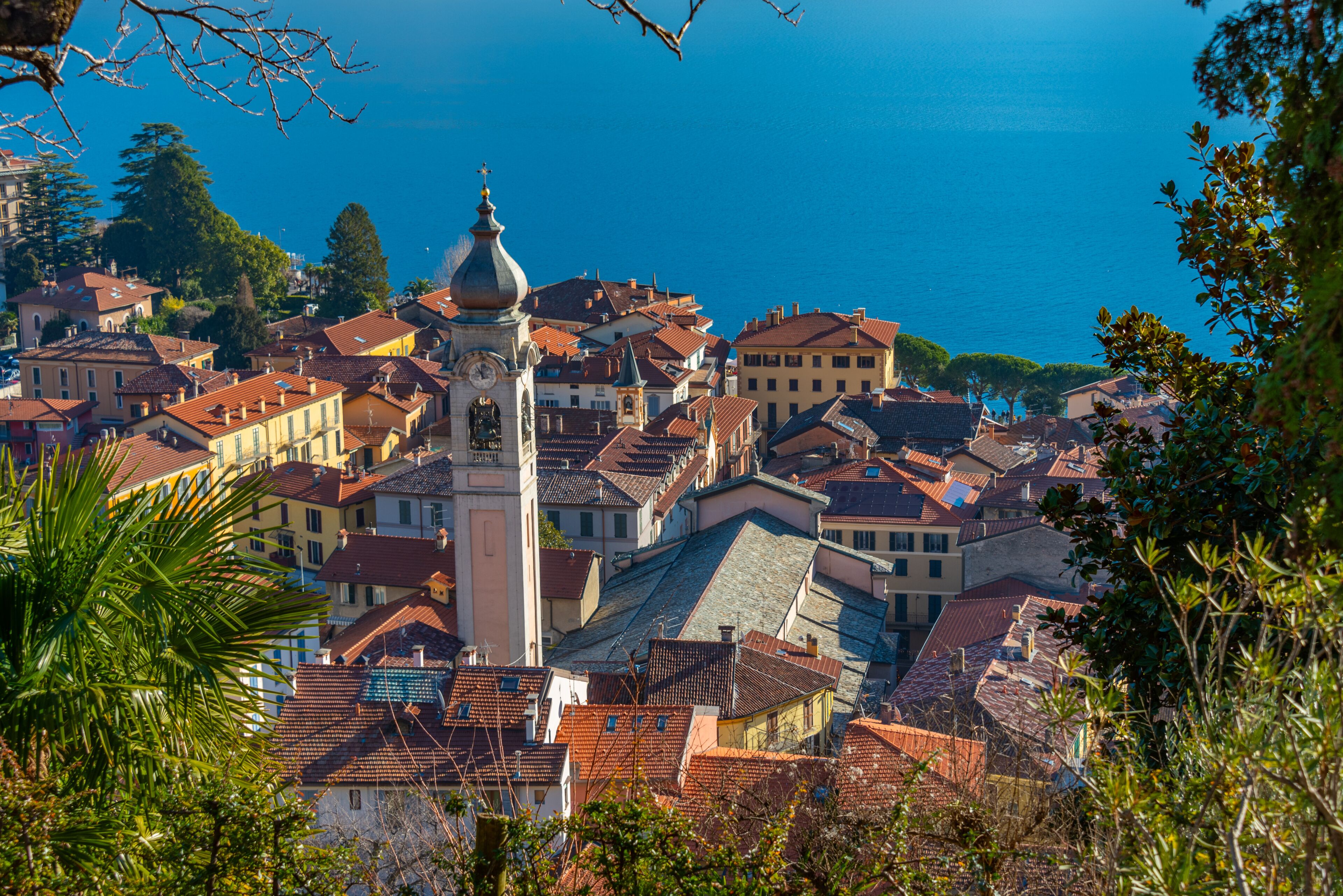 A coastal town with a prominent church tower, terraced houses, and a clear view of the sea.