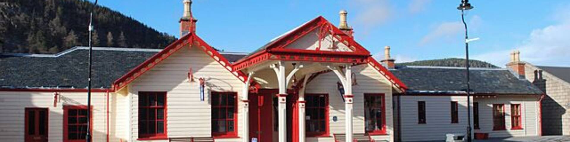 A white building with red trim and a covered waiting area.