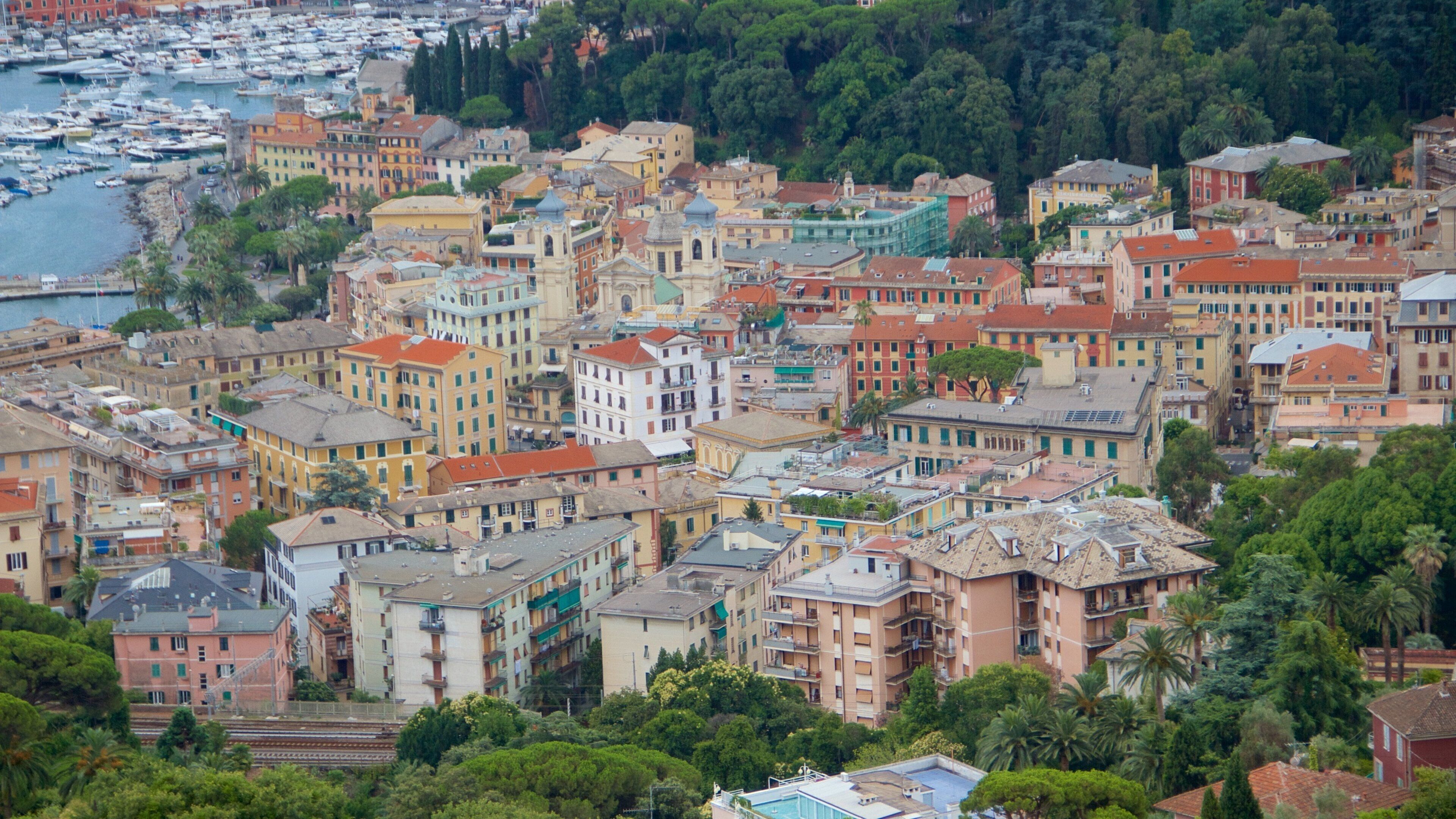 A coastal town with colorful buildings, a marina, and lush greenery.