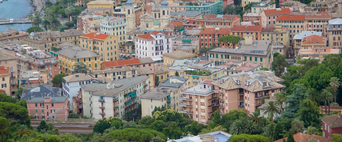 A coastal town with colorful buildings, a marina, and lush greenery.