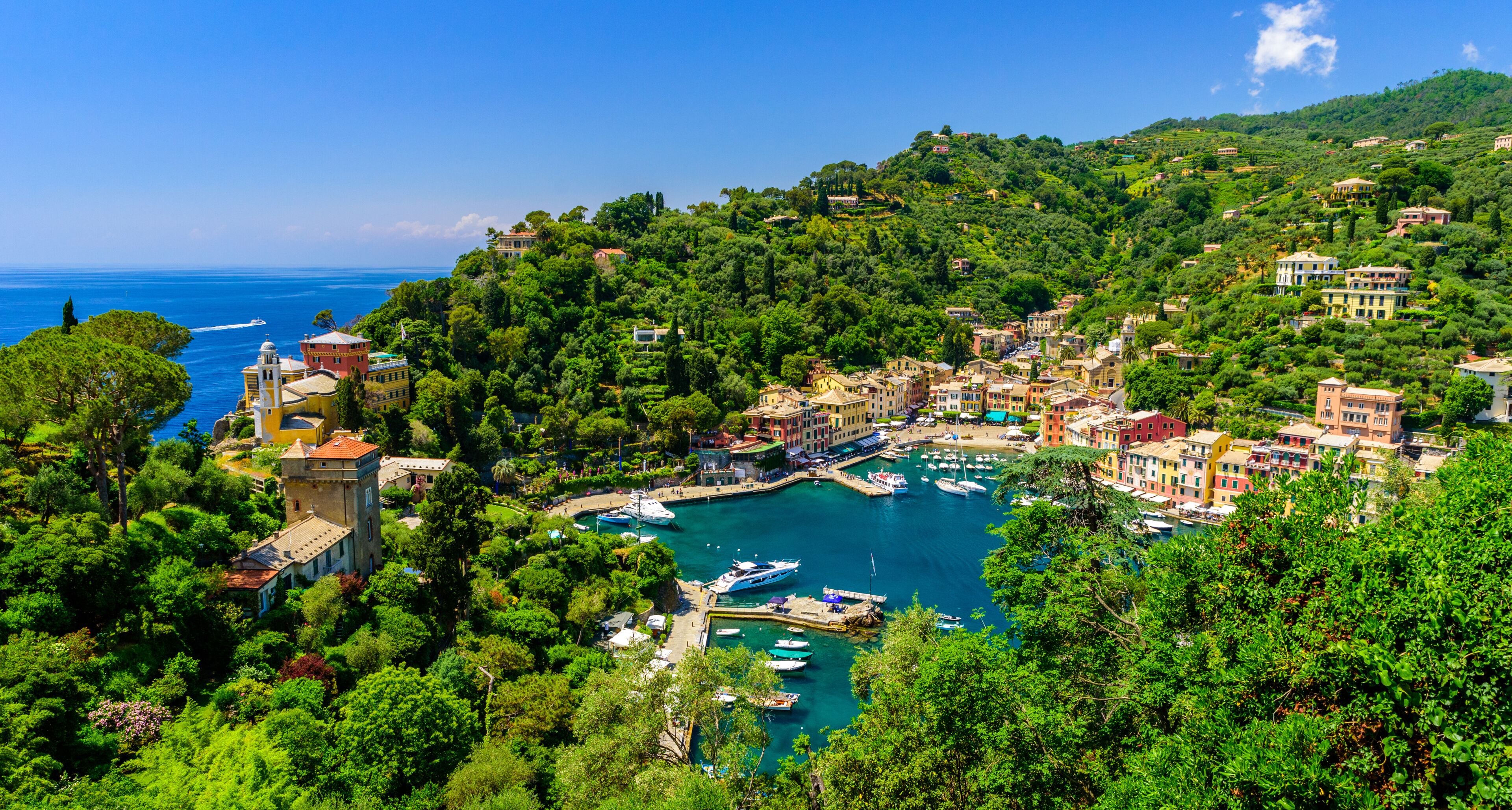 Portofino, Italy - colorful houses and yacht in little bay harbor. Liguria, Genoa province, Italy. Italian fishing village with beautiful sea coast landscape in summer season.