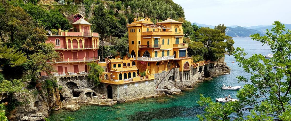 A coastal town with colorful buildings, clear turquoise waters, and boats.