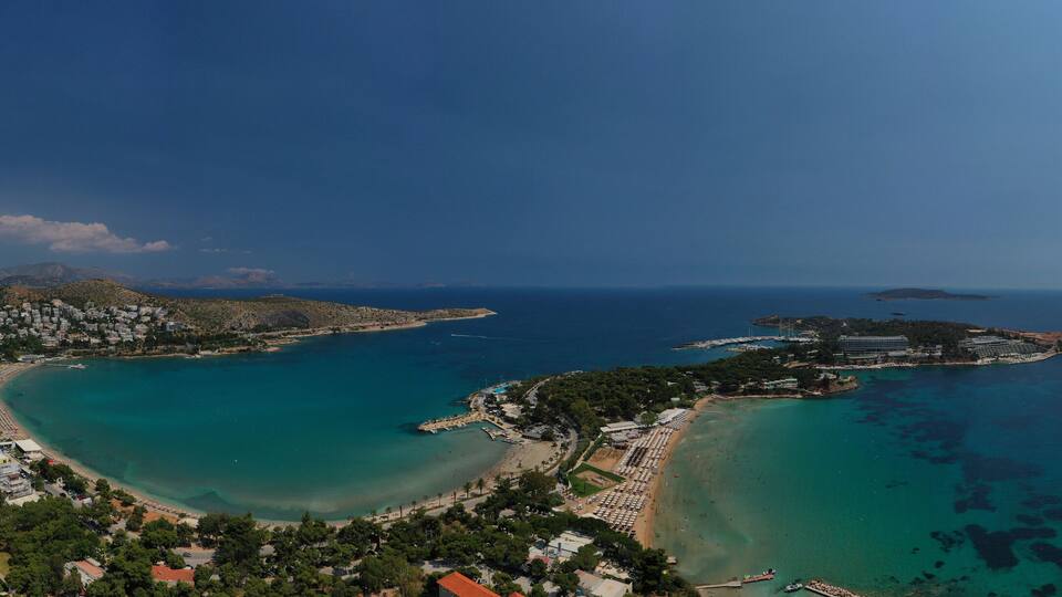 A coastal town with a bay, beaches, and a mountainous backdrop.