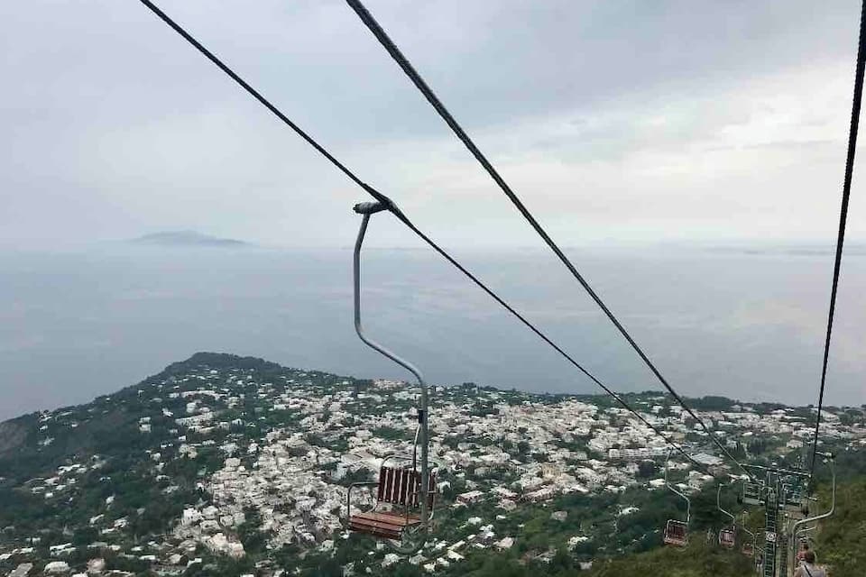 A cable car system with a mountainous landscape and a city below.