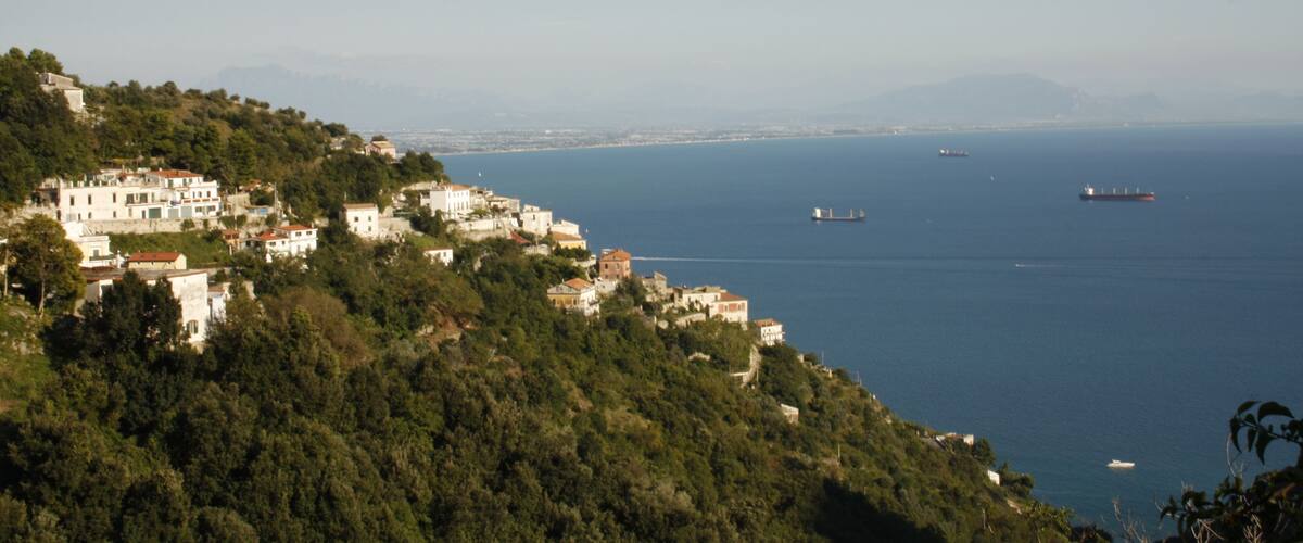 A coastal town with buildings on a hillside overlooking the sea.