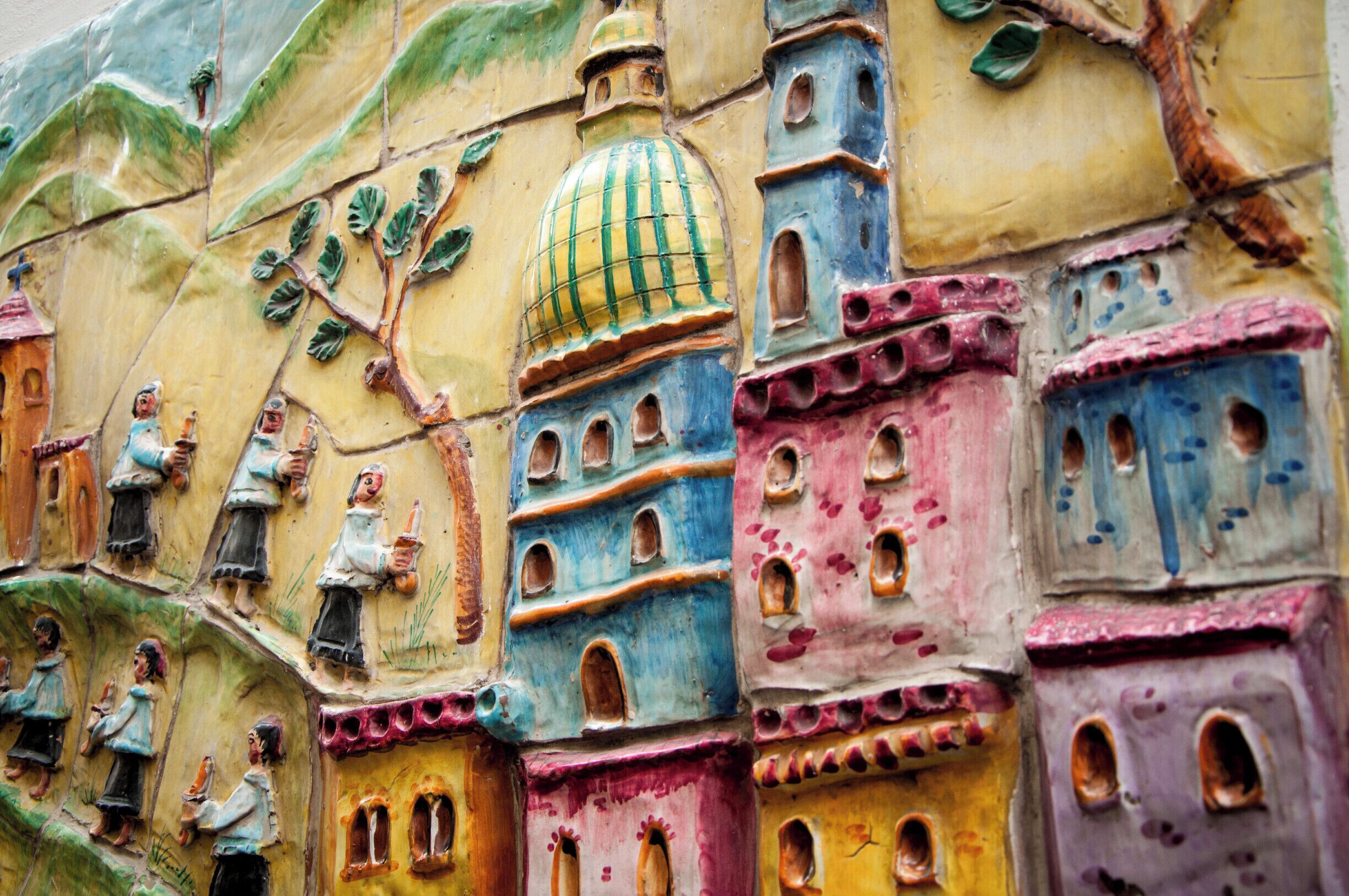 Painted majolica on the walls of the city of Vietri sul mare. All the colors of the Amalfi Coast, the sea’s deep deep blue, the striking green forests and the golden orange of the citrus groves seem to meet up in Vietri, particularly in the glazes and decorations of this gorgeous Campanian town’s beautiful ceramics, produced since 1600.Named as UNESCO World Heritage in 1997, along with the rest of the Amalfi Coast, this community not far from Salerno was struck on a splendid site amidst hills and sea.  