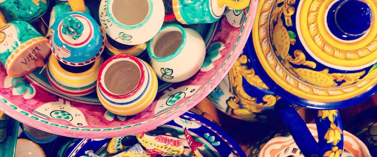 A variety of colorful ceramic mugs and cups with intricate designs.
