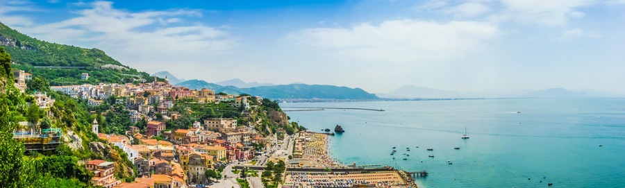 Un pueblo costero con edificios coloridos, una playa y un mar tranquilo.