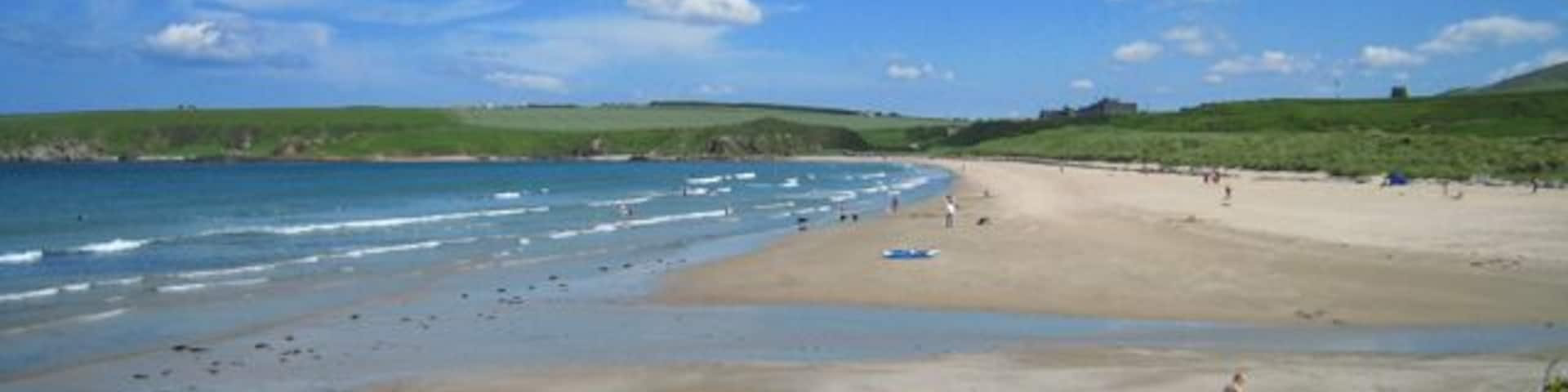 Sandend Bay Sandend lying to the west of Sandend Bay is one of the smallest of the many old fishing villages scattered along the north-facing coasts of Moray and Aberdeenshire. Sandend beach is popular with families and for surfers, especially on a day like this. At its east end, on the horizon, lies Glenglassaugh Distillery which, once again, is producing its distinctive single malt whisky after being mothballed in 1986. In the dark days of the second world war the beach was regarded as being suitable for a landing ground for the Germans and was fortified with a double row of tank traps and a gun emplacement at the east end.
