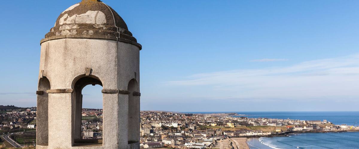 A coastal town with a prominent tower overlooking the sea.