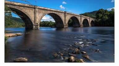 a photo of the historic bridge at Dunkeld with the river meandering along through the town