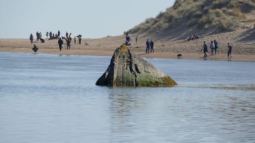 the remains of a sunken boat lie submerged in the river Ythan near Newburgh .