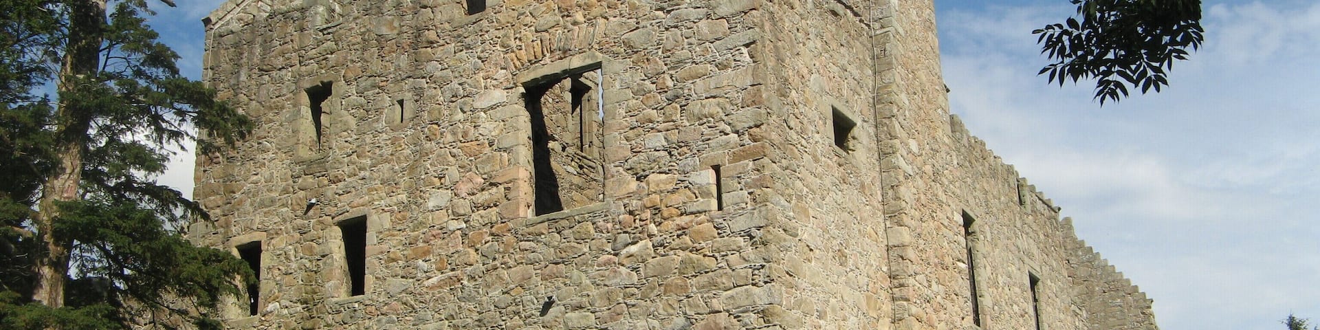 A large stone castle with multiple chimneys and windows.
