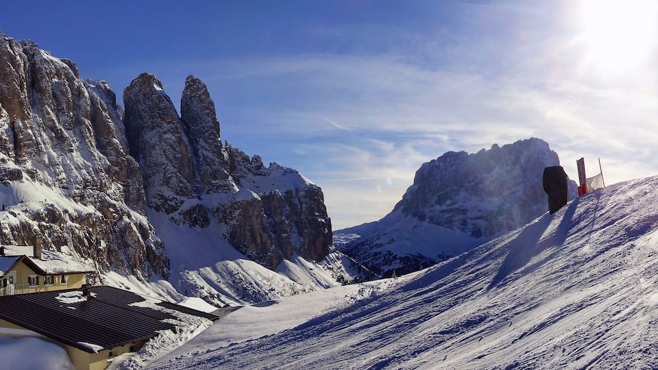 A snow-covered mountain with a hotel named "HOTEL CIR" and two skiers on a slope.