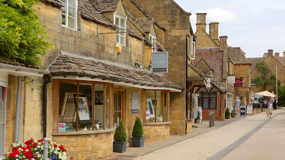 A quaint street with stone buildings, art galleries, and a cobblestone path.