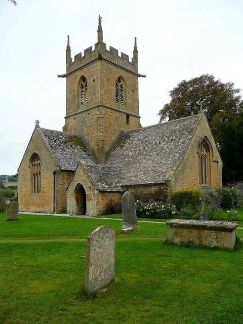 A historic church with a tall tower and a graveyard in front.
