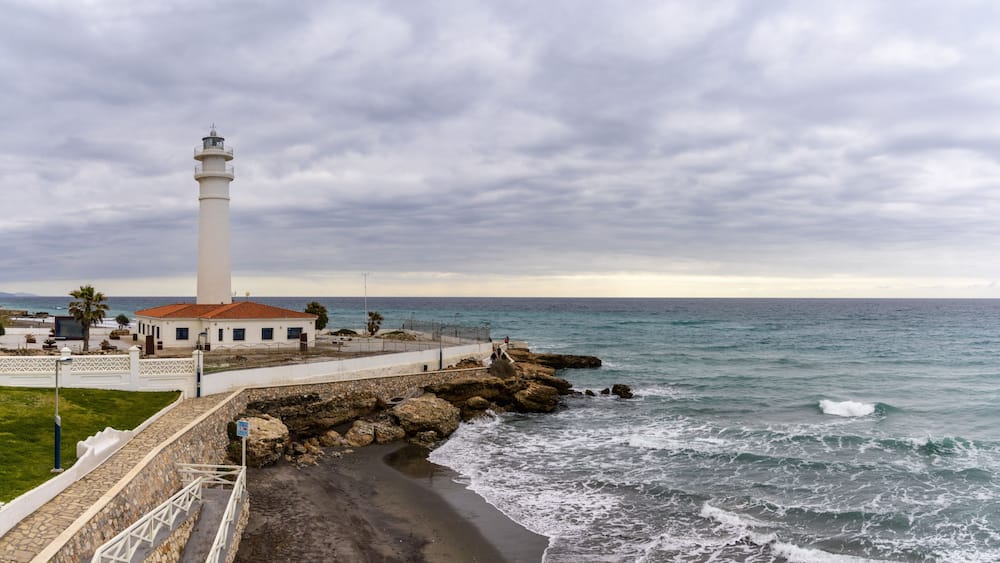 Ein Küstenleuchtturm, eine felsige Küstenlinie und ein freier Blick auf den Ozean.